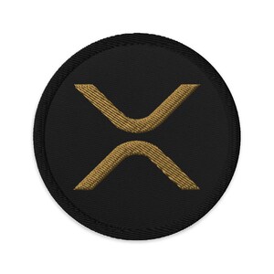 Peut inclure: Un écusson brodé noir et or avec le symbole X au centre.