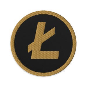 May include: A gold embroidered patch with a black background featuring the Litecoin logo, a stylized letter 'L'.