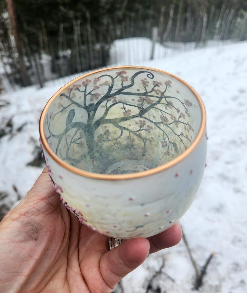 Puede incluir: Una taza de cer&aacute;mica blanca con un asa negra y el texto "But First, Coffee" en negro, con una fuente de estilo manuscrito. La taza est&aacute; sobre una superficie blanca.