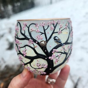 Pequeña mamá carbonera y su nido con huevos, esculpidos con arcilla polimérica sobre un portavelas de vidrio reciclado. imagen 1