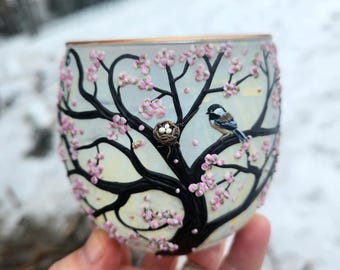 Pequeña mamá carbonera y su nido con huevos, esculpidos con arcilla polimérica sobre un portavelas de vidrio reciclado.