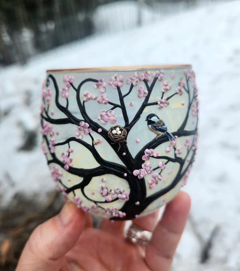 Pequeña mamá carbonera y su nido con huevos, esculpidos con arcilla polimérica sobre un portavelas de vidrio reciclado. imagen 1