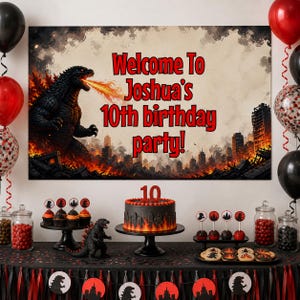 May include: A Godzilla-themed birthday party setup with a banner that reads "Welcome To Joshua's 10th birthday party!" The scene includes a cake, cupcakes, cookies, and decorations in red, black, and orange. Balloons are also present.