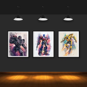 Puede incluir: Tres impresiones enmarcadas en acuarela de personajes de Transformers. Las impresiones presentan a Optimus Prime en rojo y azul, a Bumblebee en amarillo y a Megatron en gris y morado. Cada impresión está en un marco negro.