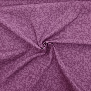 Może przedstawiać: Fioletowy materiał z małym białym wzorem kwiatowym. Materiał jest złożony i ma miękką, fakturowaną fakturę.