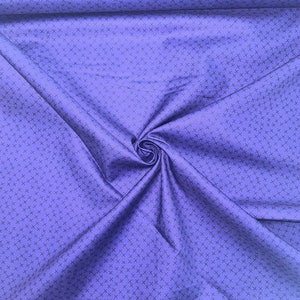 May include: A close-up of a purple fabric with a repeating pattern of small black crosses.