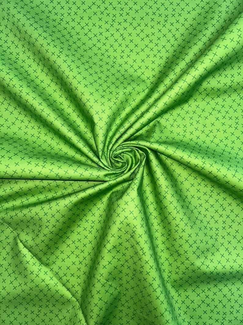 Puede incluir: Tela verde con un patr&oacute;n repetido de peque&ntilde;as cruces verde oscuro.