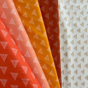 Könnte beinhalten: Vier Stoffmuster mit einem weißen geometrischen Dreiecksmuster auf verschiedenen Farbhintergründen: Orange, Pfirsich, Gelb und Weiß.