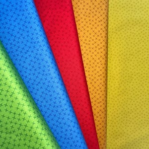 Könnte beinhalten: Fünf Stoffmuster mit einem Kreuzmuster in den Farben Grün, Blau, Rot, Orange und Gelb.