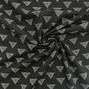 Puede incluir: Tela negra con un patr&oacute;n geom&eacute;trico blanco de tri&aacute;ngulos conc&eacute;ntricos.