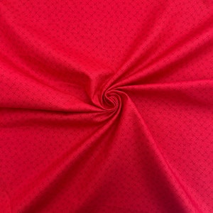 Puede incluir: Tela roja con un peque&ntilde;o patr&oacute;n de cruz blanca.