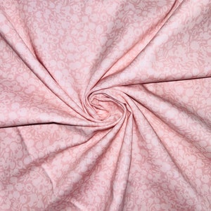 Może przedstawiać: R&oacute;żowy materiał z białym wzorem kwiatowym. Materiał jest złożony i skręcony, co ukazuje jego fakturę i wz&oacute;r.