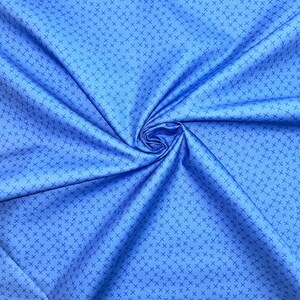 Puede incluir: Primer plano de una tela azul con un patr&oacute;n de cruces blancas. La tela est&aacute; doblada y tiene textura.