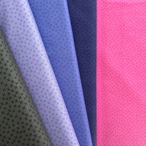 Könnte beinhalten: Fünf Stoffmuster mit einem Kreuzmuster. Die Muster sind in den Farben Schwarz, Lila, Blau und Rosa.