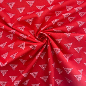 Może przedstawiać: Czerwona tkanina z powtarzającym się wzorem białych, zagnieżdżonych tr&oacute;jkąt&oacute;w. Tkanina jest zebrana w wir, pokazując teksturę i wz&oacute;r. Tr&oacute;jkąty są r&oacute;wnomiernie rozmieszczone na powierzchni.