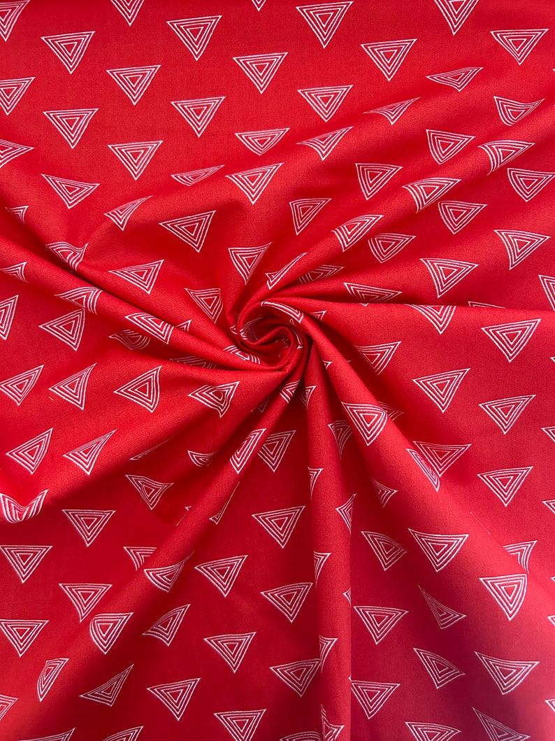 Może przedstawiać: Czerwona tkanina z powtarzającym się wzorem białych, zagnieżdżonych tr&oacute;jkąt&oacute;w. Tkanina jest zebrana w wir, pokazując teksturę i wz&oacute;r. Tr&oacute;jkąty są r&oacute;wnomiernie rozmieszczone na powierzchni.