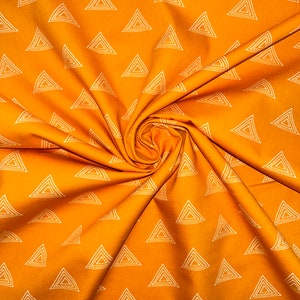 Puede incluir: Tela naranja con un patr&oacute;n geom&eacute;trico blanco de tri&aacute;ngulos repetidos. La tela est&aacute; doblada y texturizada.