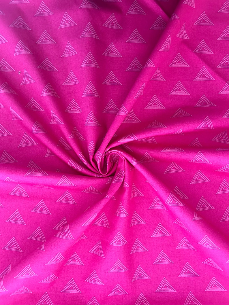 Może przedstawiać: Jasnor&oacute;żowa tkanina z powtarzającym się wzorem białych tr&oacute;jkąt&oacute;w. Materiał jest zebrany w wir, pokazując teksturę i fałdy materiału. Tr&oacute;jkąty są r&oacute;wnomiernie rozmieszczone na powierzchni.