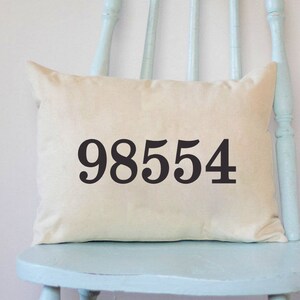May include: A light blue wooden chair with a white pillow featuring the number 98554 printed in black.