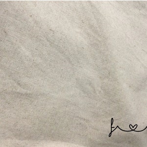 May include: A close-up of a plain, off-white canvas fabric with the word "fresh" written in cursive with a heart in the "o".