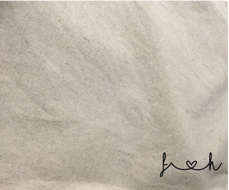 May include: A close-up of a plain, off-white canvas fabric with the word "fresh" written in cursive with a heart in the "o".