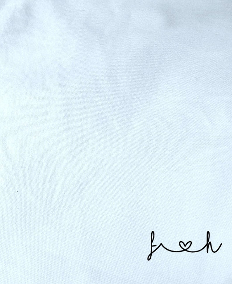 May include: A white fabric background with the word "fresh" written in black cursive with a heart in place of the "o".