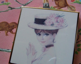 compact mirror with girl in a hat