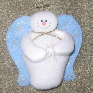 May include: A white snowman angel ornament with blue glitter wings. The snowman is holding a white sparkly star.