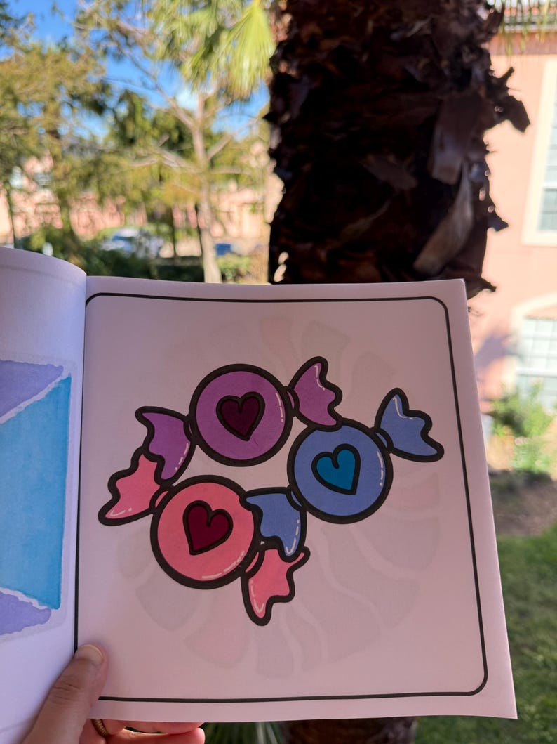 May include: A coloring page featuring three candy hearts with different colors and heart designs. The candy hearts are pink, purple, and blue.