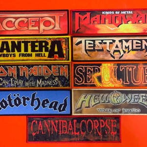 May include: A collection of nine rectangular embroidered patches featuring heavy metal band logos and text including Accept, Manowar, Pantera Cowboys From Hell, Testament, Iron Maiden Can I Play With Madness, Sepultura, Motörhead, Helloween Walls Of Jericho, and Cannibal Corpse.