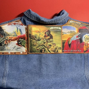May include: A blue denim jacket with three embroidered patches. The patches display fantasy artwork and the band name "Helloween", with album titles "Keeper of the Seven Keys" and "Walls of Jericho".