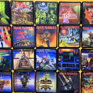 Puede incluir: Una colección de veinte parches de tela cuadrados que presentan varias ilustraciones de portadas de álbumes y sencillos de Iron Maiden. Cada parche tiene un borde negro y muestra diseños gráficos coloridos y detallados con el nombre Iron Maiden.