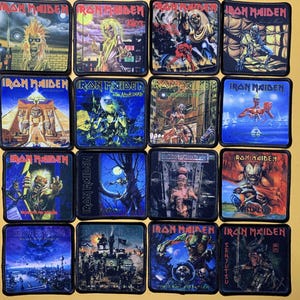 Può includere: Una collezione di toppe di Iron Maiden con illustrazioni di album. Ogni toppa quadrata presenta illustrazioni vivaci con il logo della band. Le toppe mostrano vari temi, tra cui elementi fantasy e horror, con una tavolozza di colori scuri.