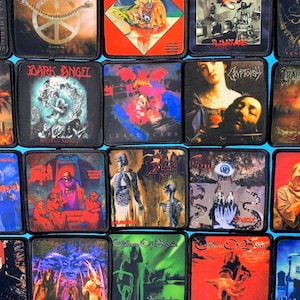 Puede incluir: Una colección de parches de tela cuadrados con diversas portadas de álbumes de heavy metal. Cada parche muestra ilustraciones detalladas y coloridas que incluyen esqueletos, figuras oscuras y logotipos de bandas como Death y Dark Angel.