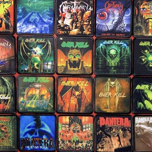 Pode incluir: Uma coleção de patches quadrados com arte de álbuns de várias bandas de heavy metal. Os patches exibem cores e imagens vibrantes, incluindo caveiras, demônios e logotipos de bandas. As bandas incluem Obituary, Overkill e Pantera.