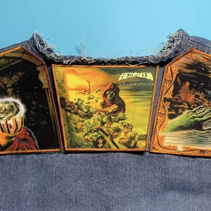 Könnte beinhalten: Drei Helloween-Bandaufnäher sind auf eine Jeansweste genäht. Die Aufnäher zeigen Albumcover mit Fantasy-Themen, darunter eine Figur in Robe, die eine leuchtende Kugel hält, eine Figur in einer Kapuzenrobe und eine ausgestreckte Hand. Die Aufnäher sind goldfarben gerahmt.