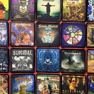 May include: A collection of square patches featuring album art and band logos. The patches display various designs, including skulls, figures, and text like "Suicidal Tendencies" and "Friends & Family."