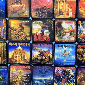 Peut inclure: Une collection de vingt écussons carrés en tissu présentant des illustrations graphiques colorées de pochettes d'albums de heavy metal. Chaque écusson est bordé de noir et affiche des illustrations détaillées, incluant divers personnages, paysages et logos.