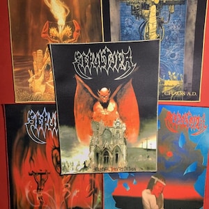 May include: A collection of five patches featuring album art from the band Sepultura. The patches display various designs, including fiery imagery, architectural structures, and the band's logo. The color palette includes red, orange, blue, and black.