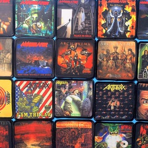 Może przedstawiać: Kolekcja dwudziestu kwadratowych naszywek z tkaniny przedstawiających różne okładki albumów heavy metalowych, w tym Annihilator, Arch Enemy, Anthrax i At The Gates, z unikalnymi grafikami, logotypami zespołów i nadrukowanym tekstem na każdej z nich.