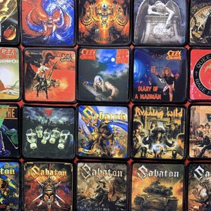 Puede incluir: Una colección de parches cuadrados con portadas de álbumes de varias bandas de heavy metal. Los parches muestran colores vibrantes e ilustraciones detalladas, incluyendo logotipos de bandas y títulos de álbumes. Los parches están dispuestos en una cuadrícula.