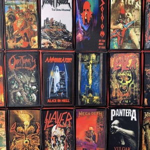 以下が含まれることがあります： ヘヴィメタルバンドのロゴとアルバムアートワークが描かれた長方形のパッチのコレクション。スカル、人物、SlayerやMegadethなどのバンド名など、鮮やかな色と詳細なイラストが特徴です。パッチはおそらく布製で、黒い縁取りがされています。