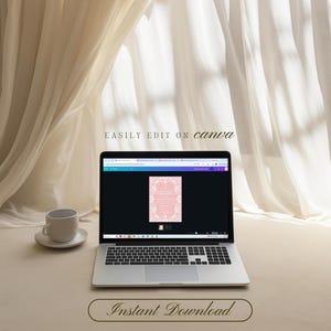 Op de afbeelding: Een laptop toont een roze uitnodigingsontwerp met bloemmotieven. De tekst "EASILY EDIT ON canva" en "Instant Download" zijn zichtbaar. Een witte kop en schotel staan links, tegen een neutrale gordijnachtergrond.