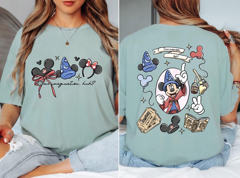 May include: A light green t-shirt featuring Disney-themed graphics. The front displays Mickey Mouse ears, a wizard hat, and Minnie Mouse ears with the text "Some imagination, huh?" The back showcases Mickey as a wizard, tickets, and other themed elements.