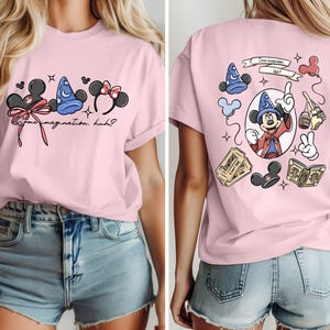 May include: Pink t-shirt featuring Disney-themed graphics. The front displays Mickey Mouse ears, a sorcerer's hat, and Minnie Mouse ears with text that reads "Some imagination, huh?" The back shows Mickey Mouse as a sorcerer.