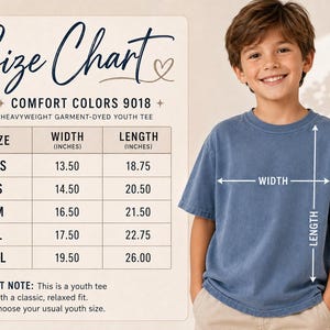 May include: A size chart for a Comfort Colors 9018 heavyweight garment-dyed youth tee. The chart lists sizes XS through XL with corresponding width and length measurements in inches. A blue t-shirt is shown with arrows indicating width and length.