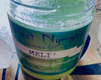 Könnte beinhalten: Ein klares Glas mit grünem Apfelzucker-Peeling. Das Etikett lautet "Forest Nymphs Handmade Bath & Body" und "MELI' Apple Sugar Scrub". Das Glas hat 473 ml und einen durchsichtigen Deckel.
