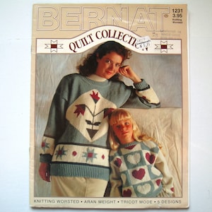 May include: A magazine cover featuring a quilt collection with two women wearing knitted sweaters. The magazine is titled "Bernat Quilt Collection" and features a quilt pattern on the cover.