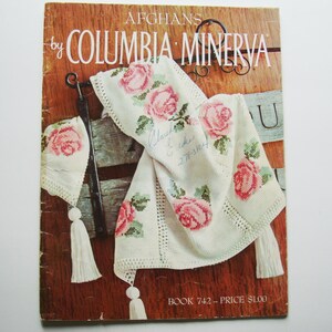Peut inclure: Une couverture de livre vintage pour un livre de modèles de crochet intitulé "Afghans by Columbia Minerva". La couverture présente un afghan crocheté avec un motif floral dans les tons de rose et de vert. Le livre est vendu 1,00 $.