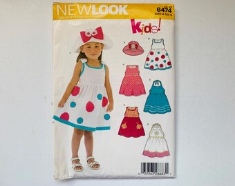 New Look Kids! Patrón sin cortar 6474 para niña pequeña, talla A - 1/2 a 4 años. Vestido de verano sin mangas con cuello halter y sombrero de ala ancha.
